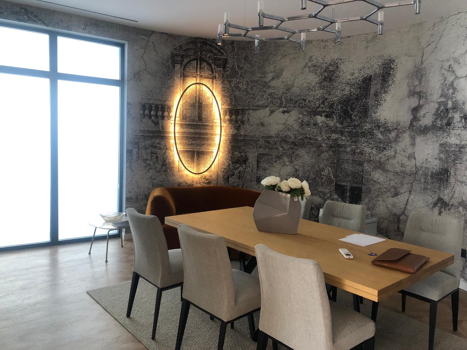 Sufragerie premium cu frescă murală și corp de iluminat sculptural.